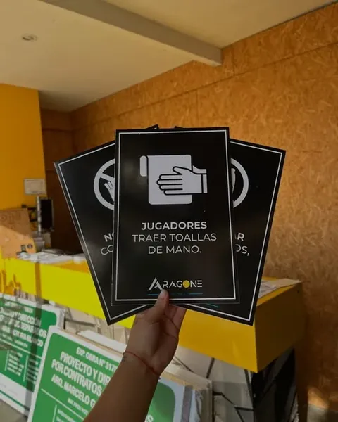 Señales negras y blancas con indicaciones para usuarios de un espacio deportivo