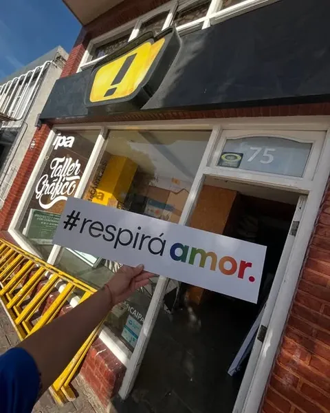 Frente del taller Gráfica IPA en Eneas 75, con su cartel amarillo y negro